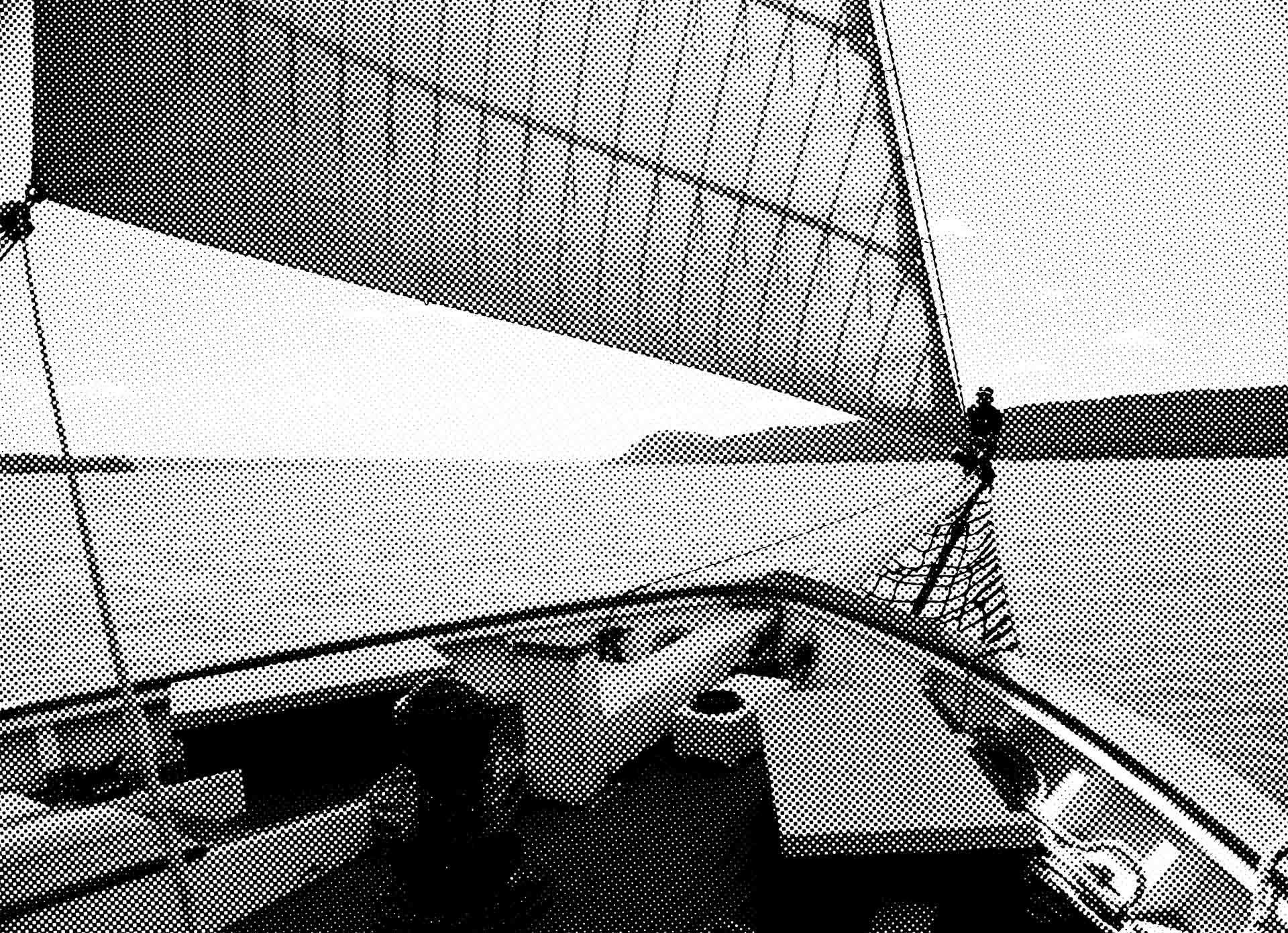 A halftone image of the sloop Clearwater out on the Hudson River, looking toward the bow, with the jib unfurled and filled with wind.